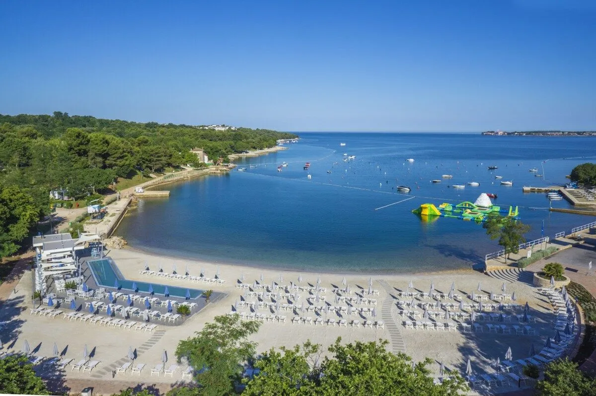 Scenic beach with clear blue water and boats.