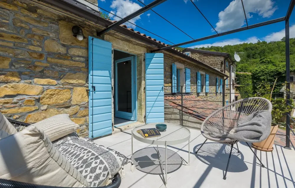 Charming stone house patio with blue shutters.
