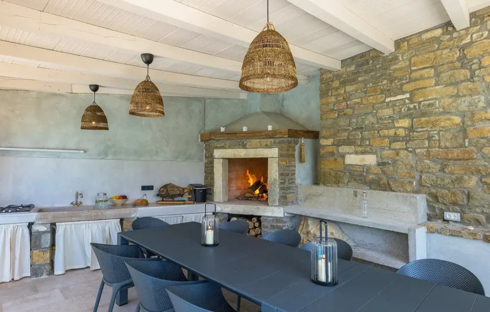 Rustic dining area with large fireplace and stone walls.