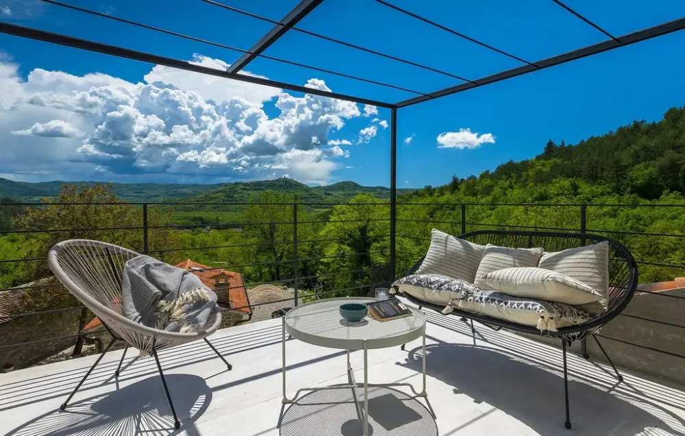 Scenic terrace with seating and forest view.
