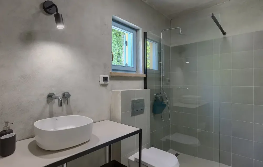 Modern bathroom with gray tiles and white fixtures.