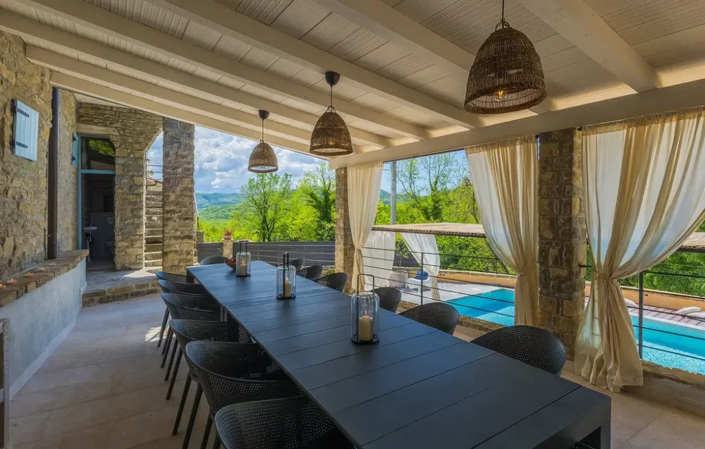 Outdoor dining area with pool and scenic view.