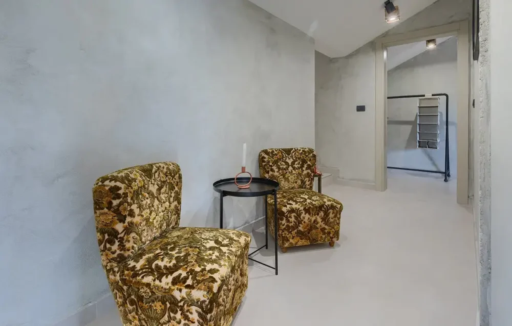 Vintage chairs with floral patterns in a hallway.