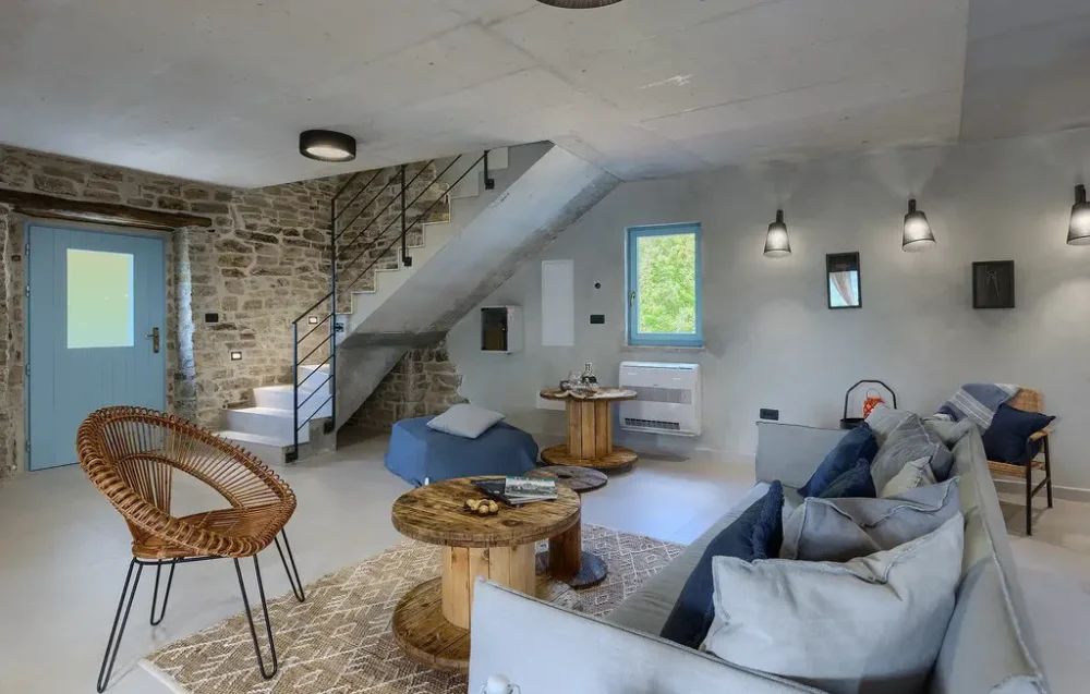 Modern living room with rustic decor and staircase.