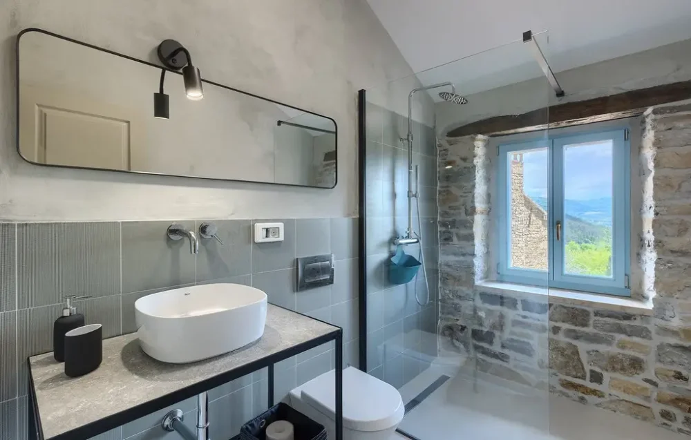 Modern bathroom with stone walls and shower.