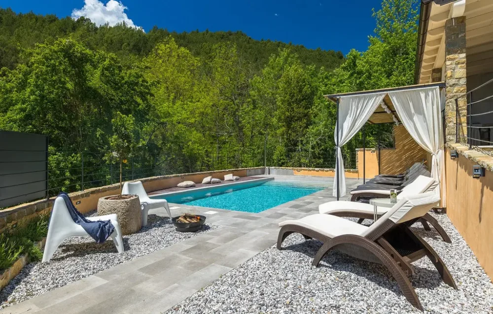 Outdoor pool with lounge chairs and canopy.
