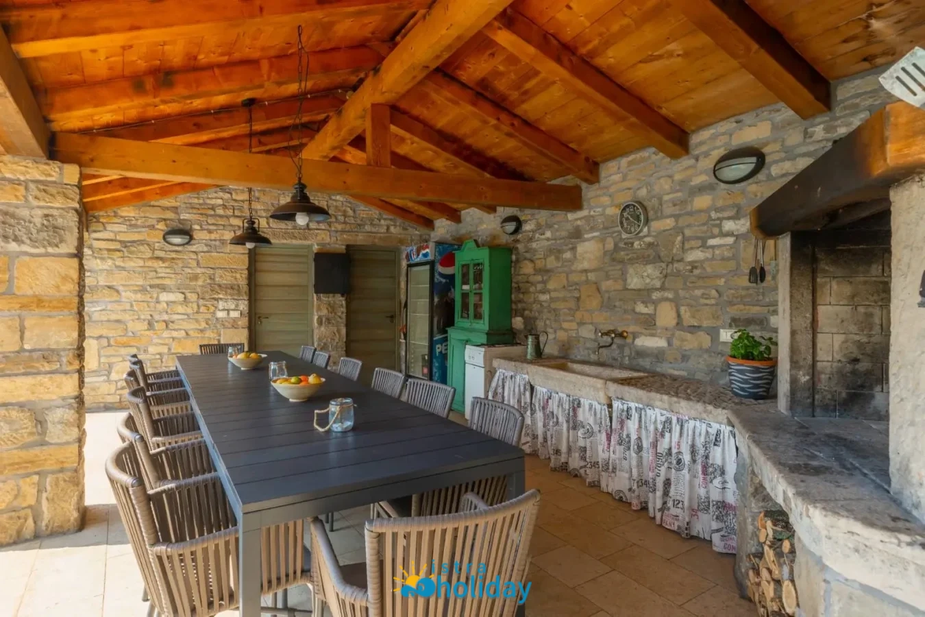 Rustic outdoor dining area with stone wall and table.