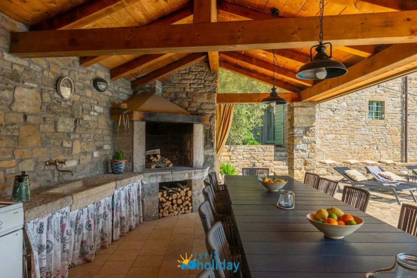 Outdoor stone kitchen and dining area with fireplace.