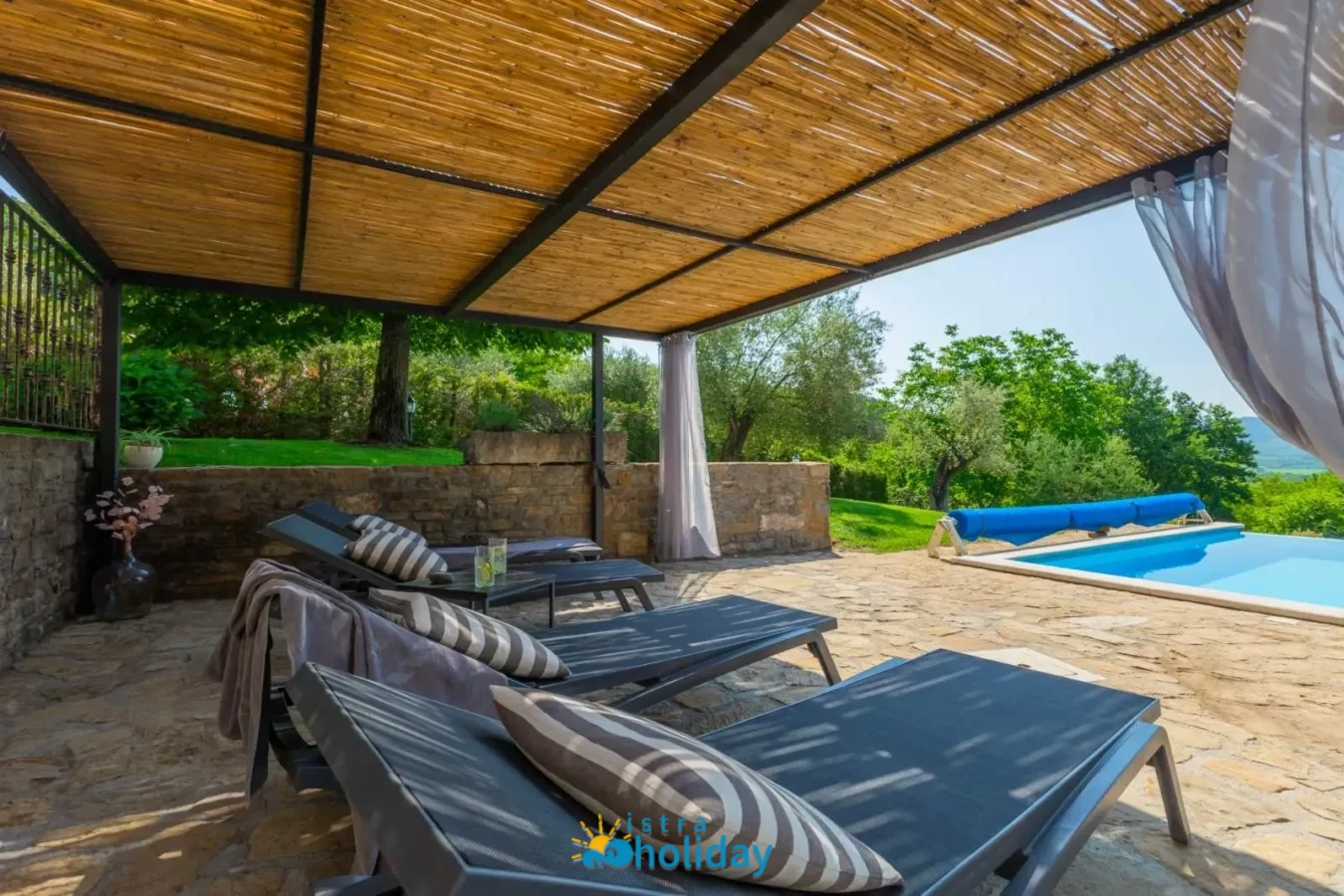 Outdoor poolside lounge area with sunbeds and canopy.