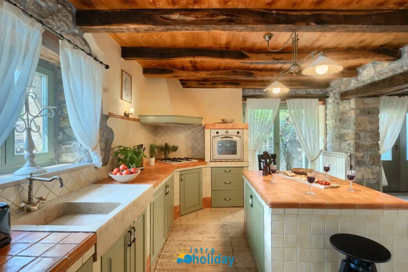 Rustic kitchen with wooden beams and stone walls.