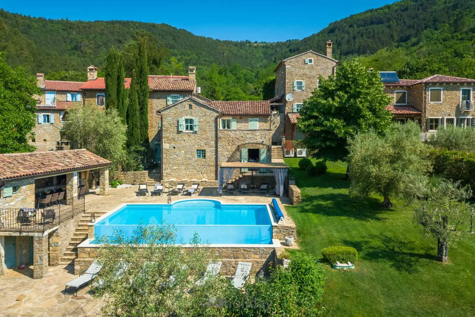 Rustic villa with pool in lush countryside setting.