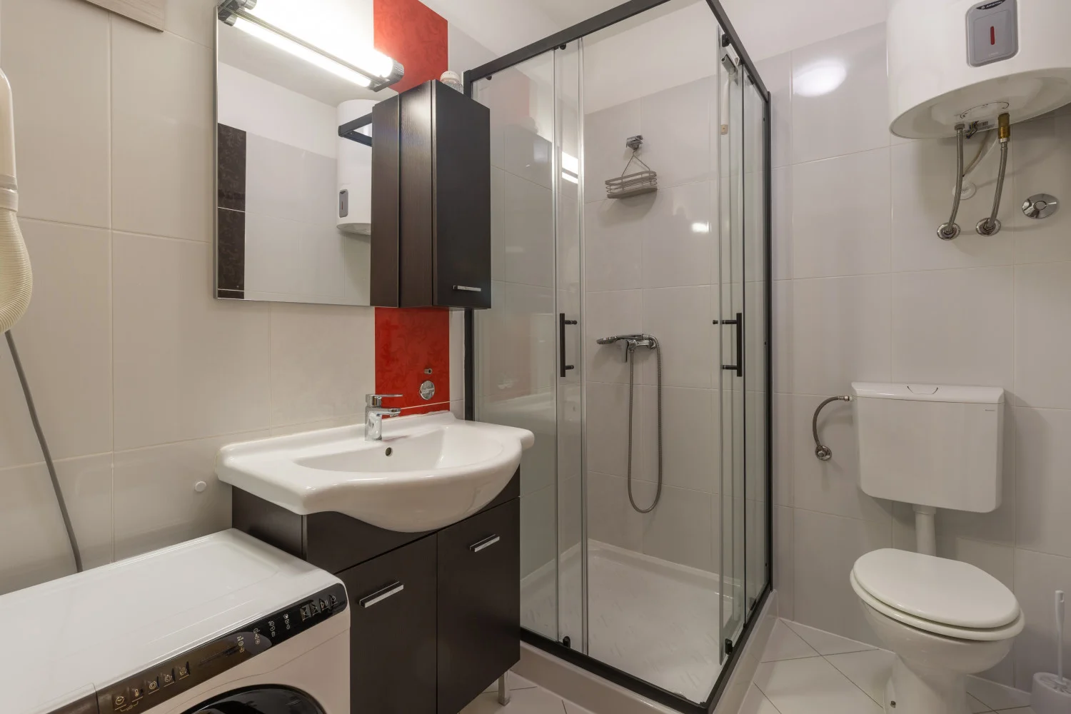 Modern bathroom with shower, sink, toilet, and washer