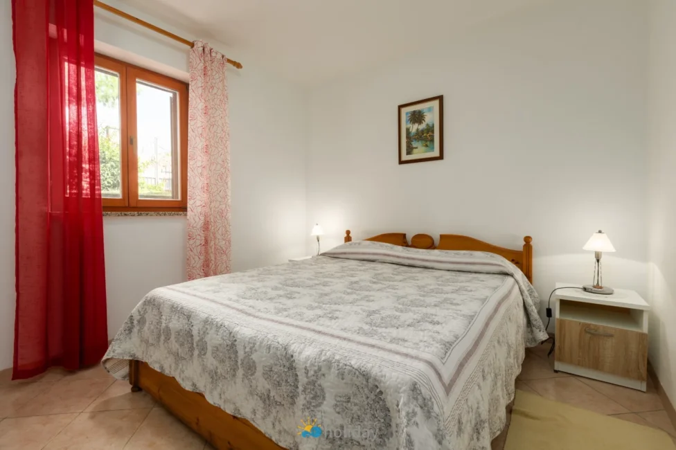 Bright bedroom with wooden bed and red curtains