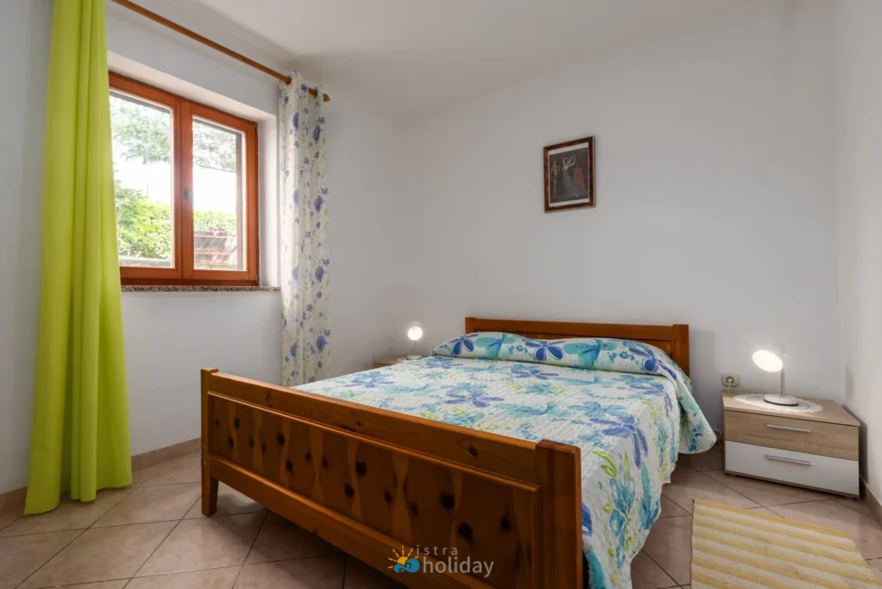 Bright bedroom with wooden bed and floral bedding