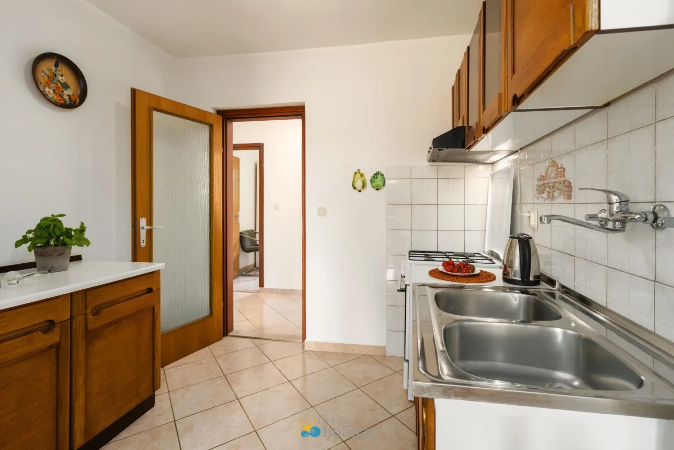 Compact kitchen with wooden cabinets and double sink