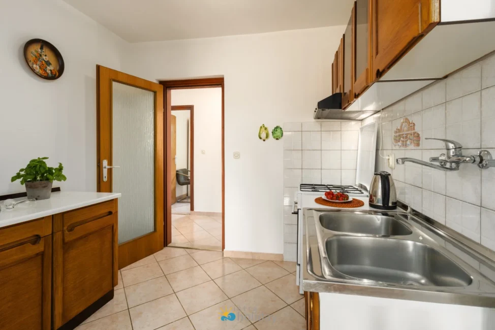 Compact kitchen with wooden cabinets and double sink