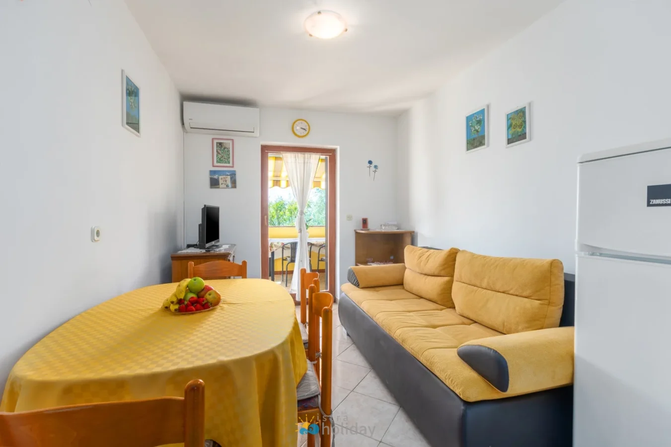 Bright living room with yellow sofa and dining table