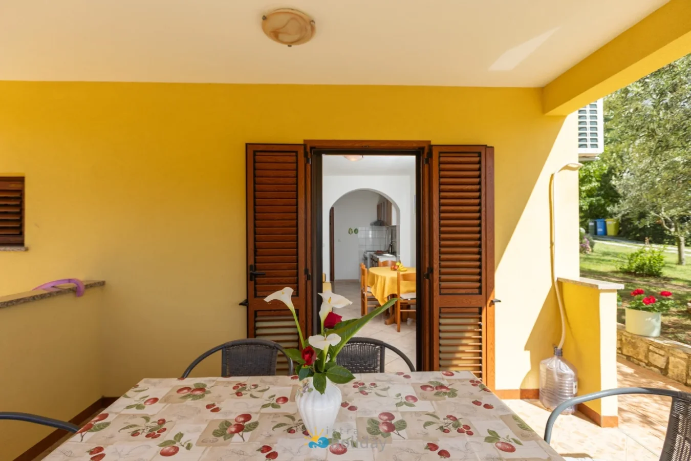 Covered patio with table and open wooden shutters