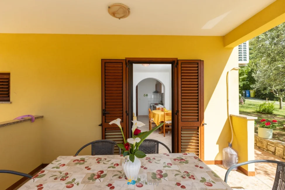 Covered patio with table and open wooden shutters