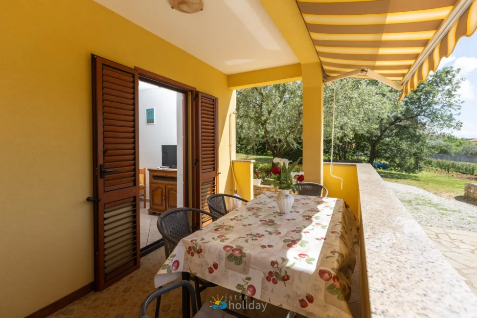 Sunny yellow patio with table and garden view