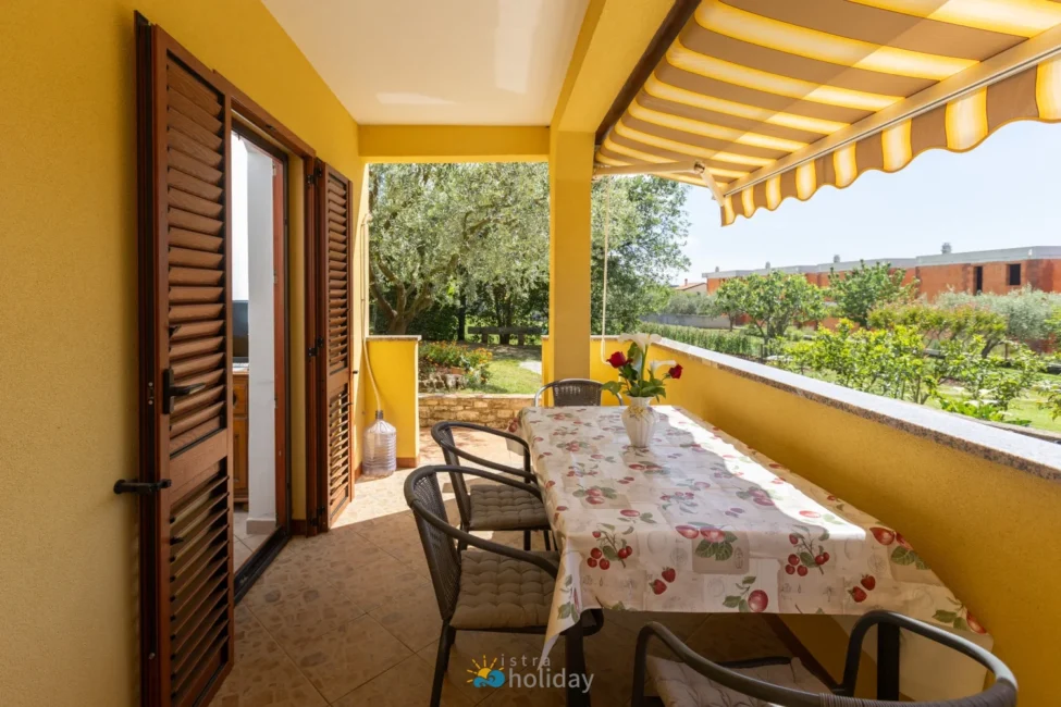 Sunny yellow patio with table and garden view