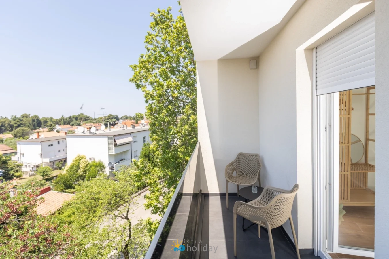 Modern apartment balcony with chairs and neighborhood view