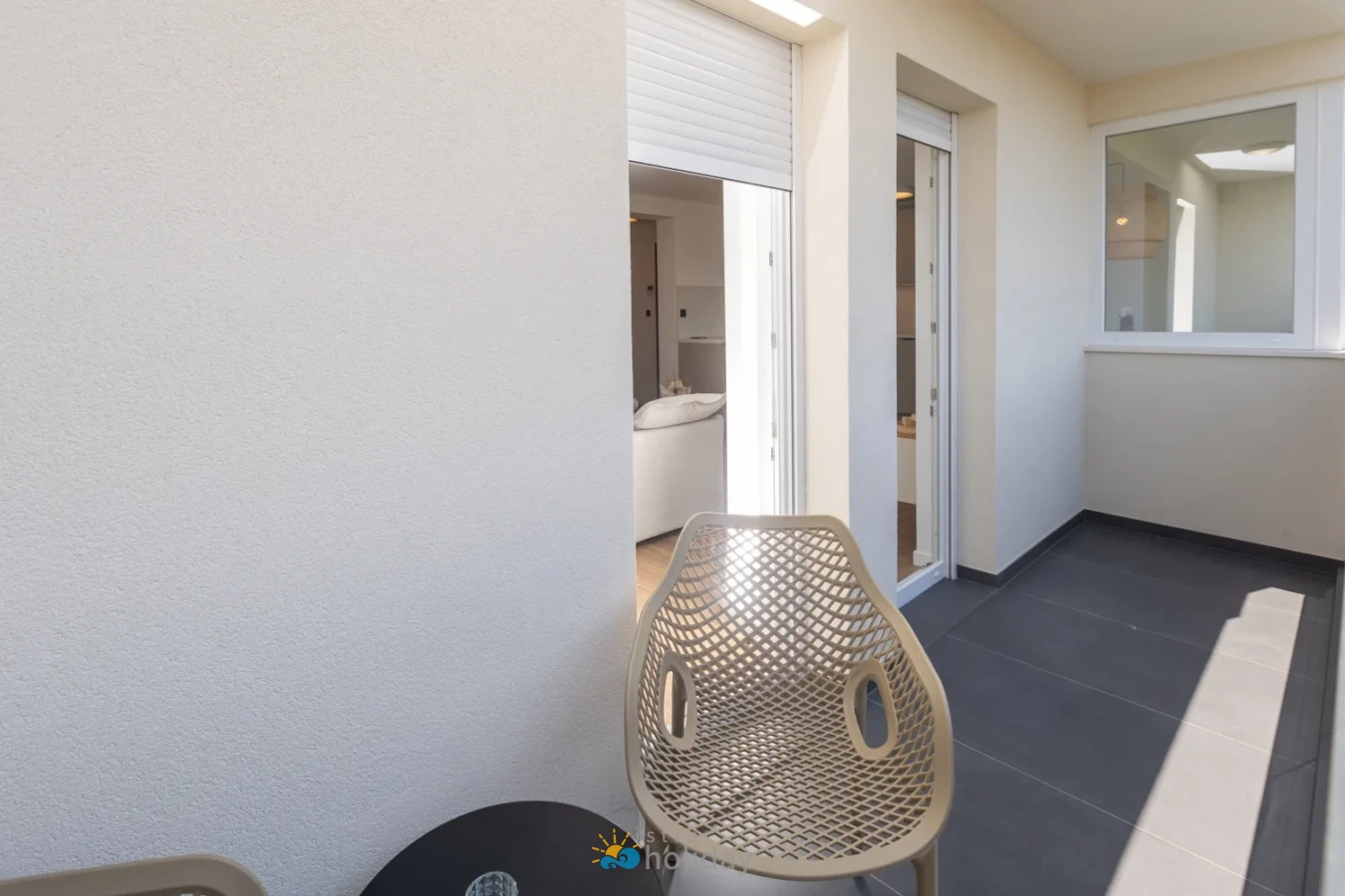 Modern apartment balcony with chair and sliding doors