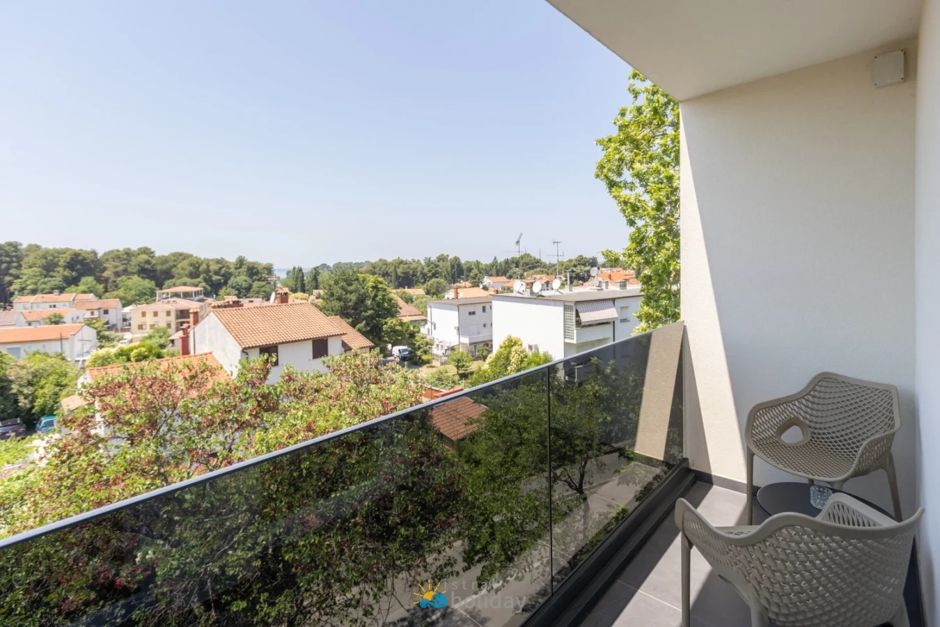 Balcony with chairs overlooking leafy residential neighborhood