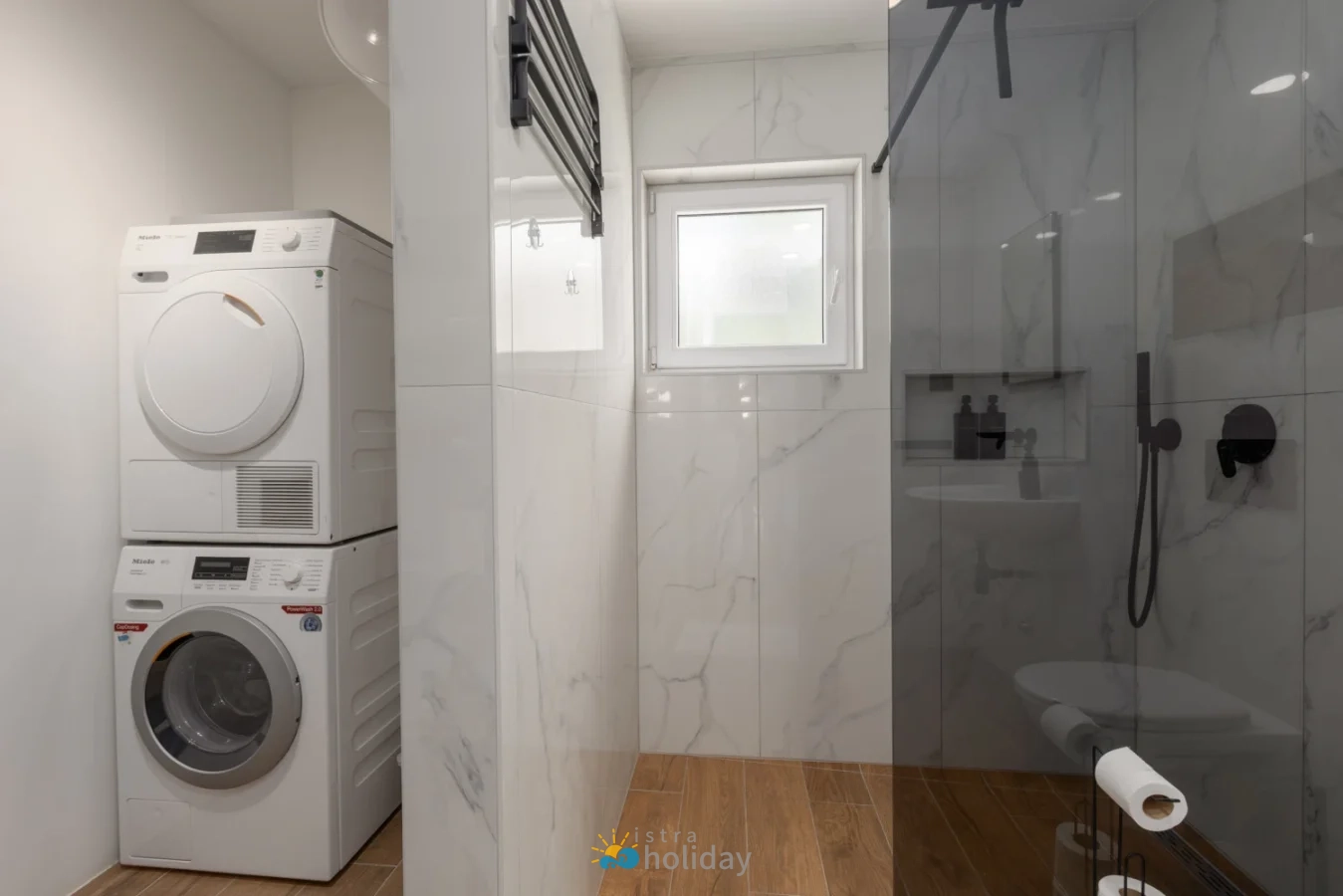 Modern bathroom with stacked washer dryer and glass shower