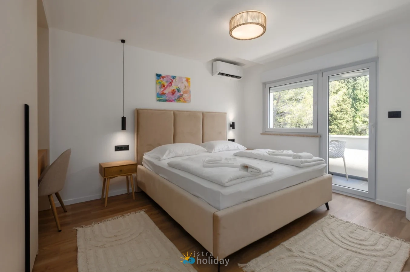 Modern bedroom with beige bed and balcony view
