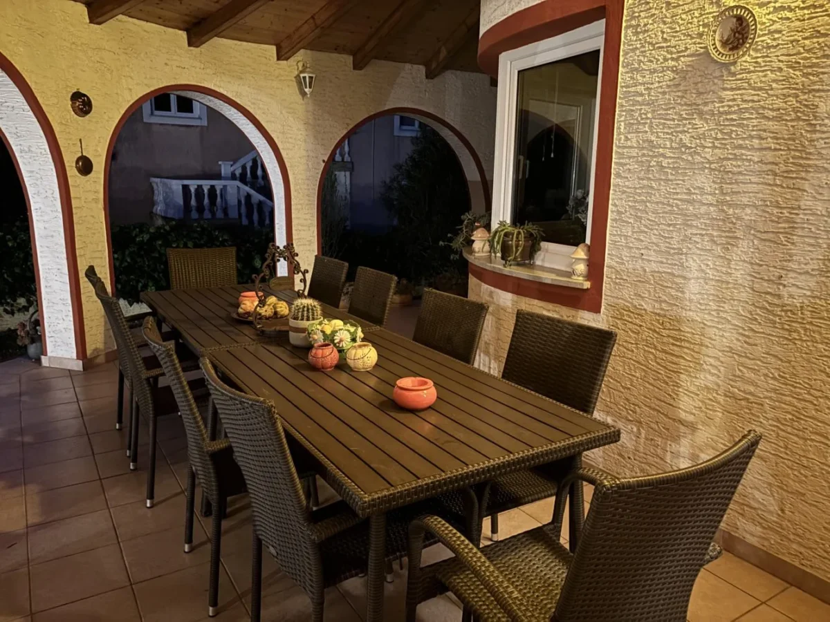 Outdoor dining table with chairs and decor items.