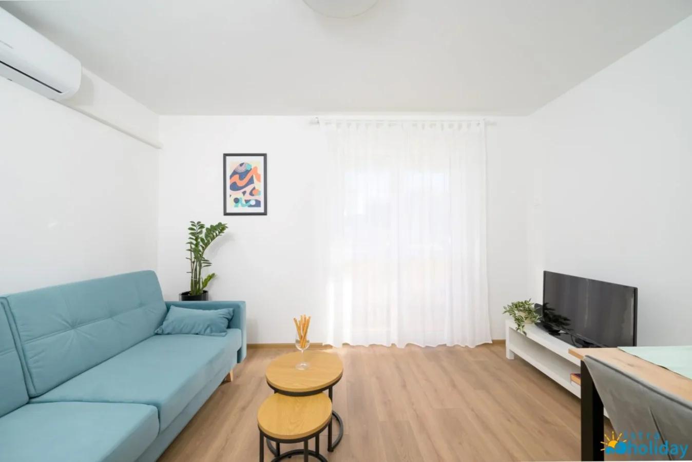 Modern living room with blue sofa and TV.
