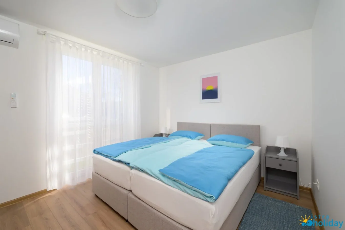 Bright modern bedroom with double bed and window.