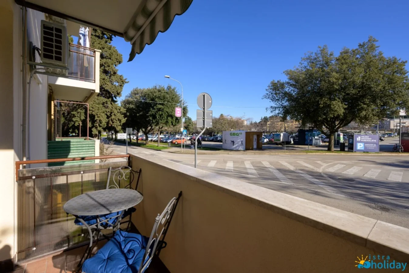Sunny balcony with street view and table.