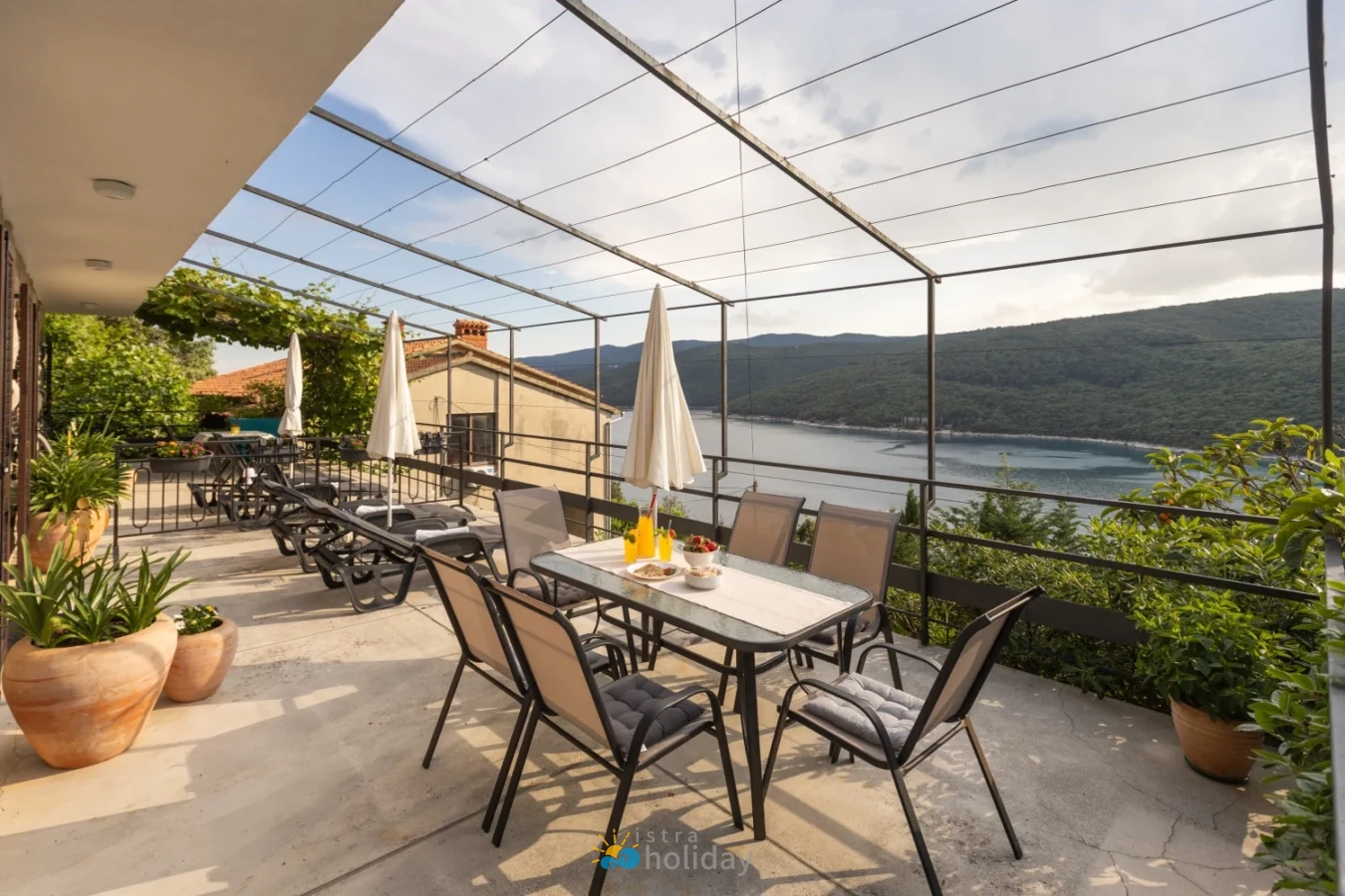 Lakeside terrace with dining table and loungers