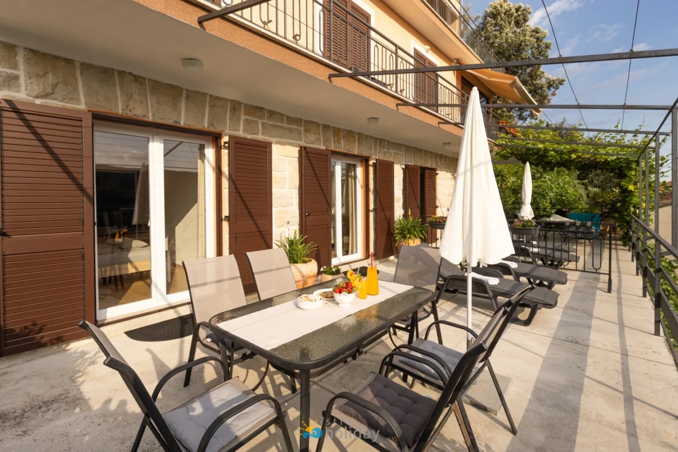 Sunny terrace with outdoor dining and lounge chairs