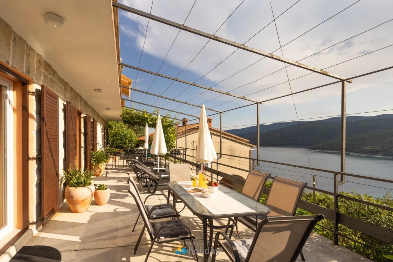 Seaside terrace with dining table and mountain view