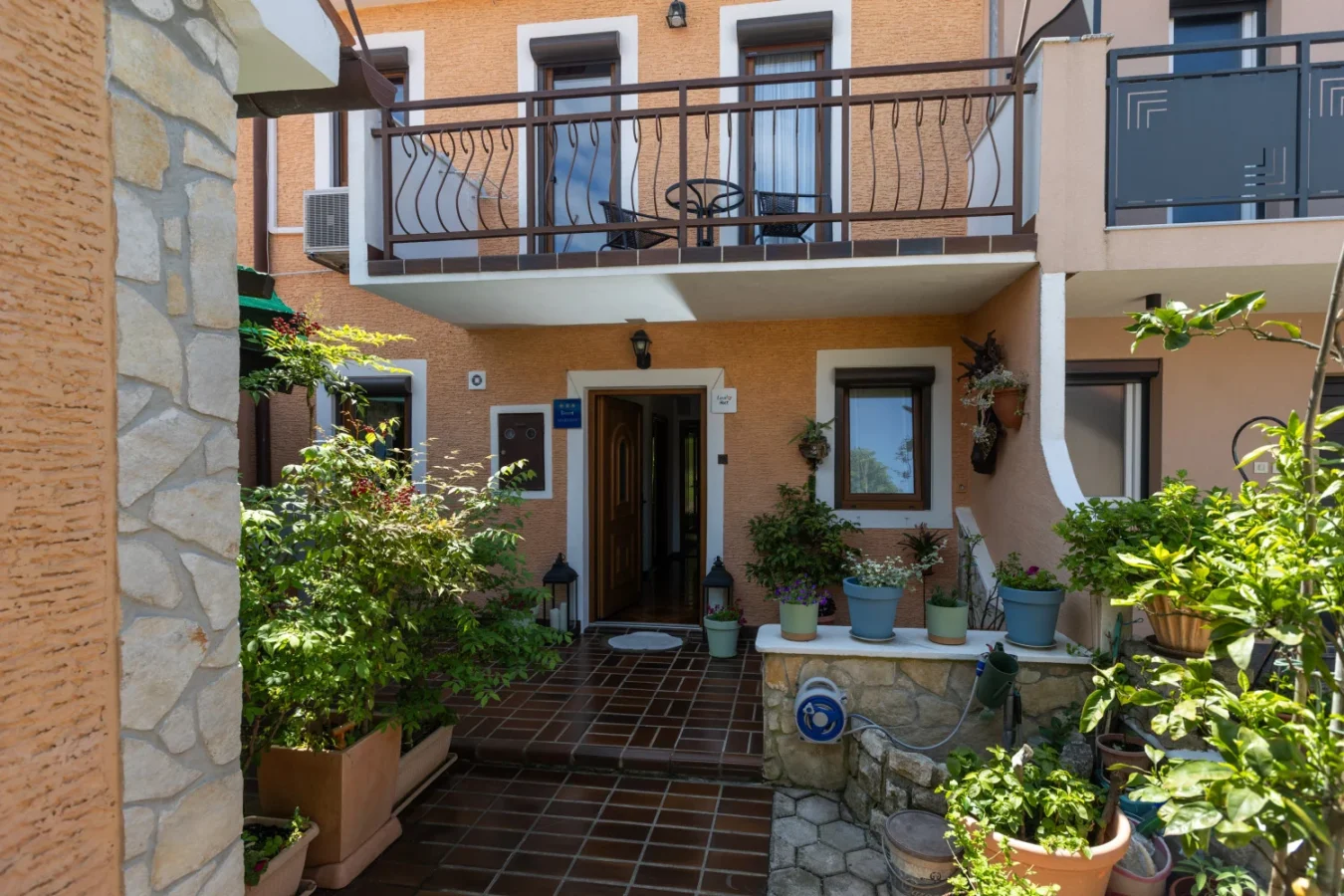 Charming house entrance with balcony and potted plants