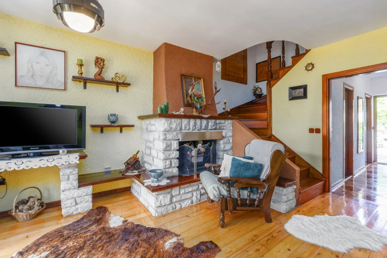 Cozy living room with stone fireplace and stairs