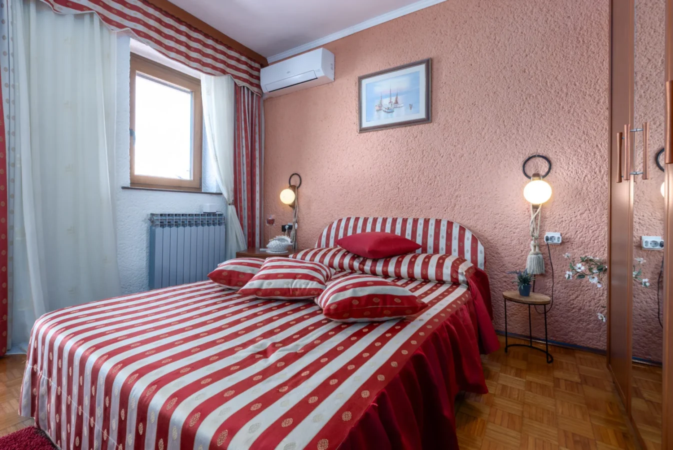 Cozy bedroom with red striped bedding and peach walls