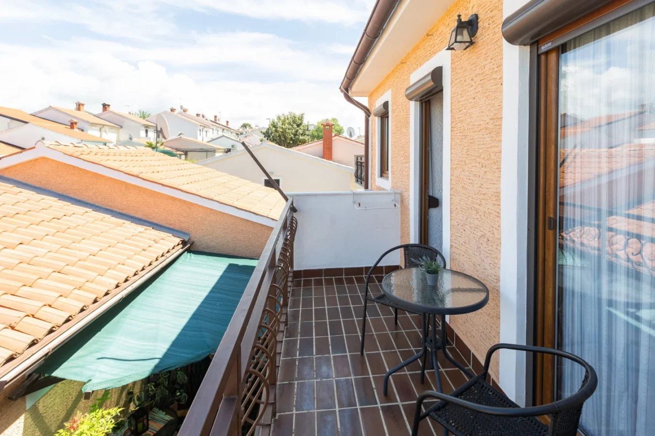 Small balcony with table overlooking tiled rooftops
