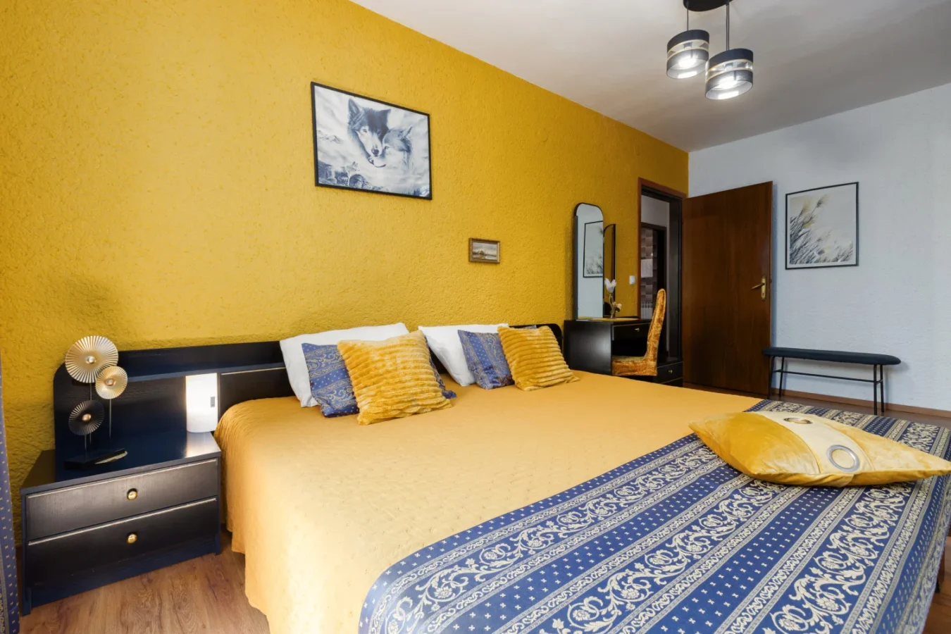 Modern bedroom with yellow accent wall and king bed