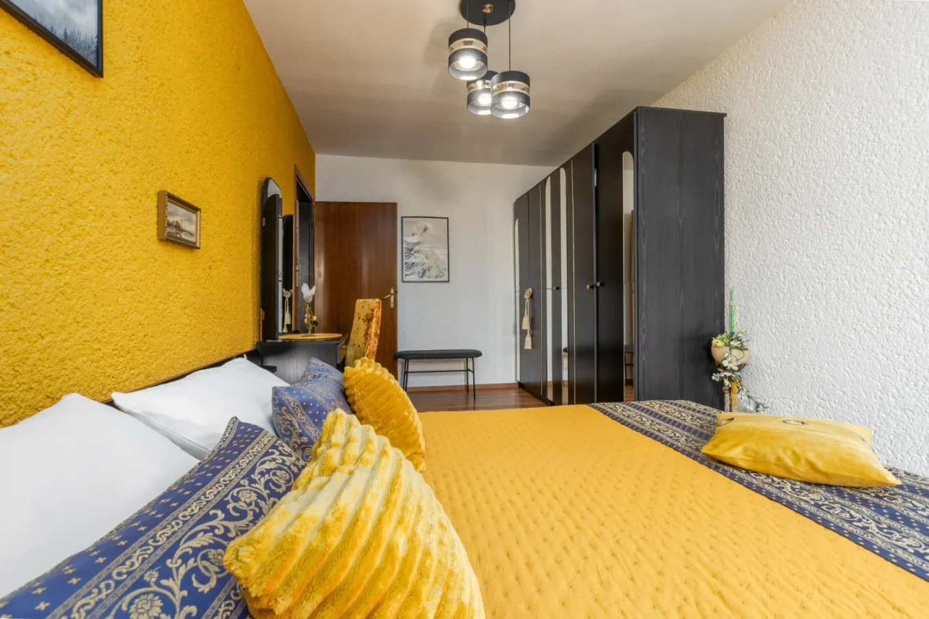 Modern bedroom with yellow accent wall and bedding