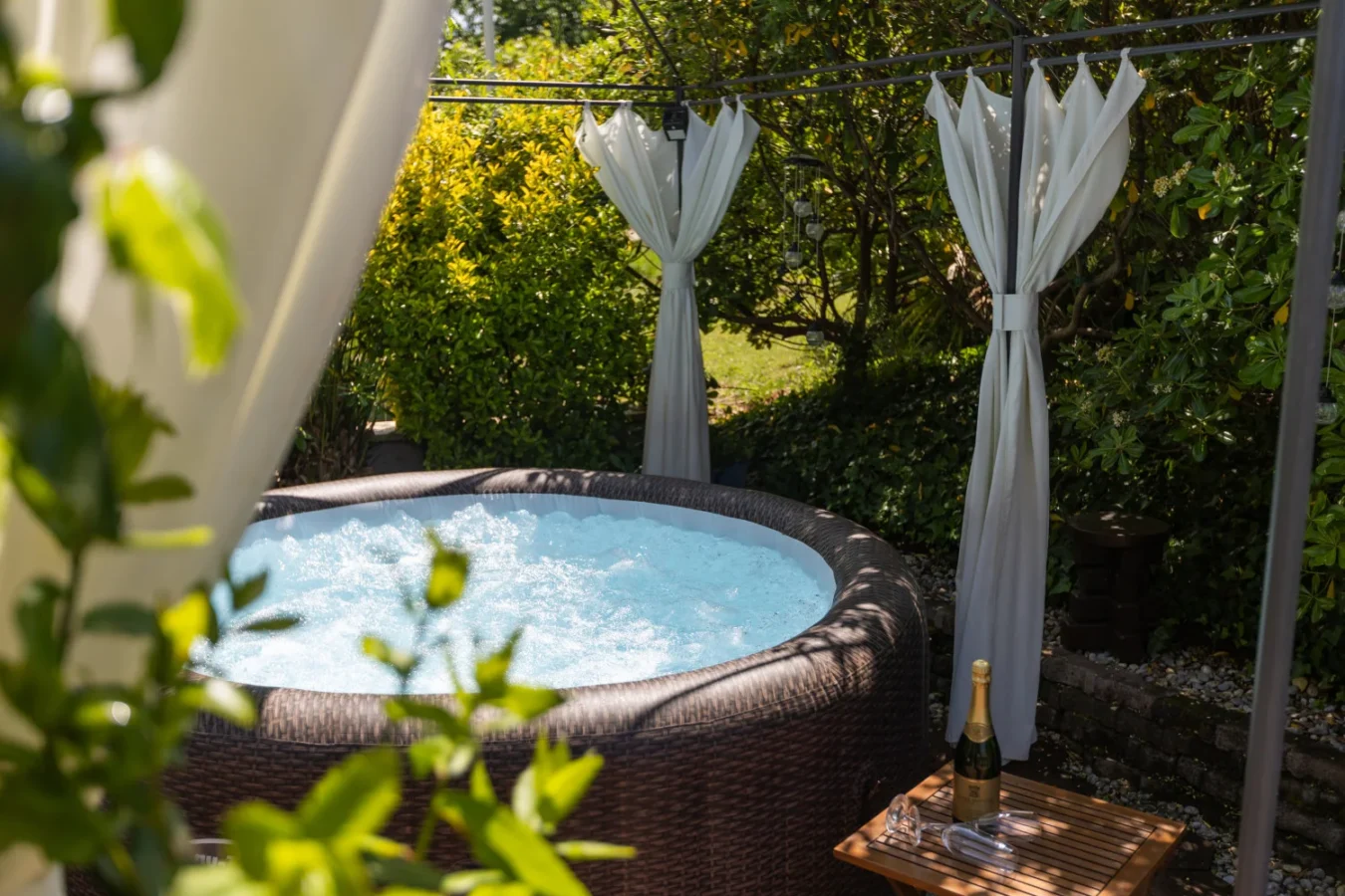Outdoor hot tub with champagne under garden gazebo