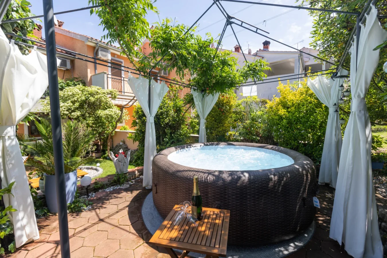 Outdoor hot tub under gazebo in garden