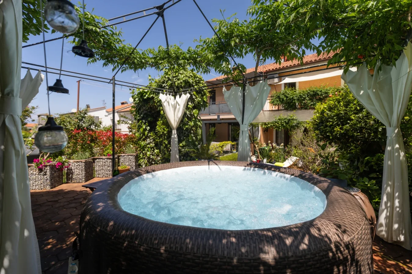Outdoor inflatable hot tub under garden pergola