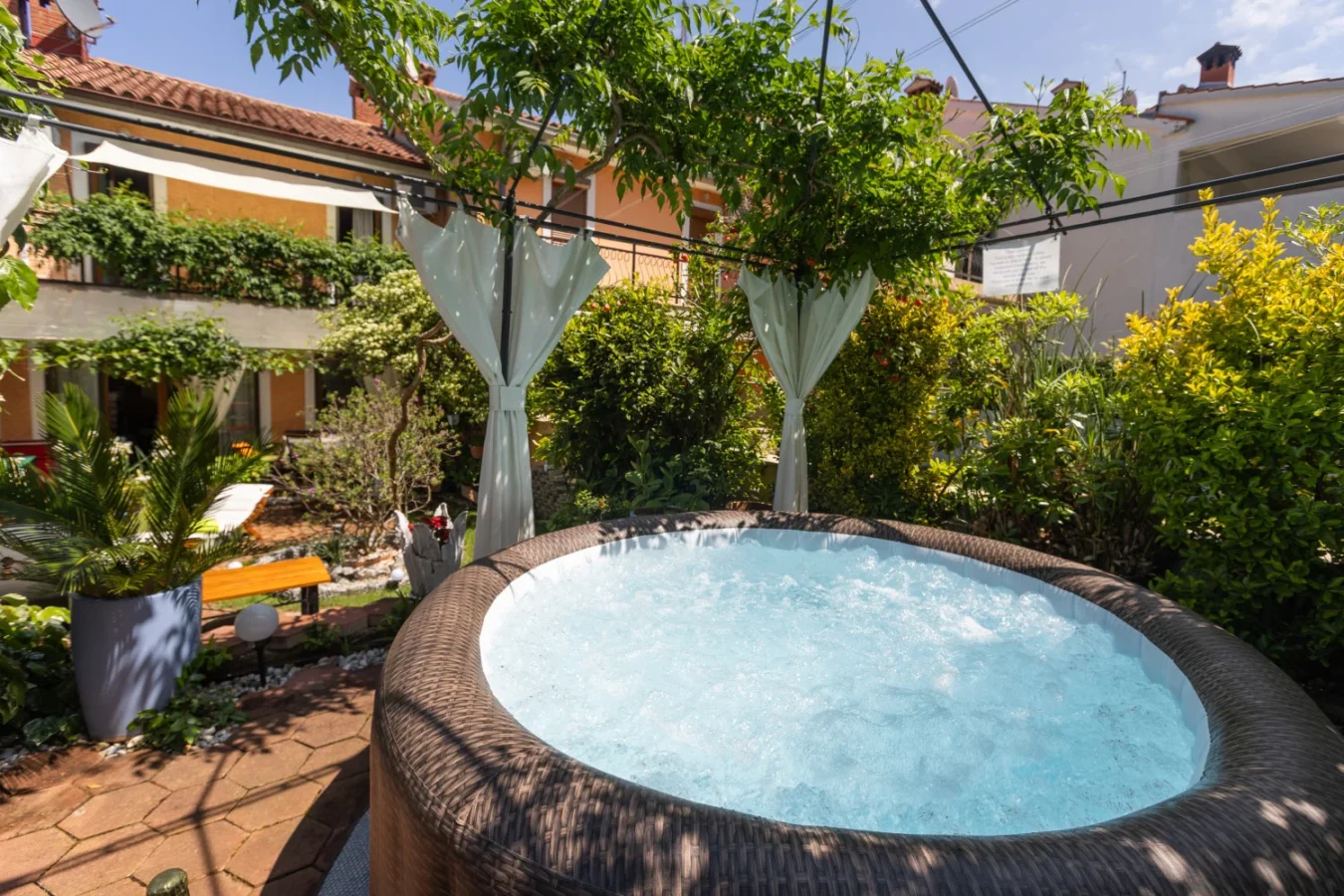 Outdoor hot tub in lush garden courtyard