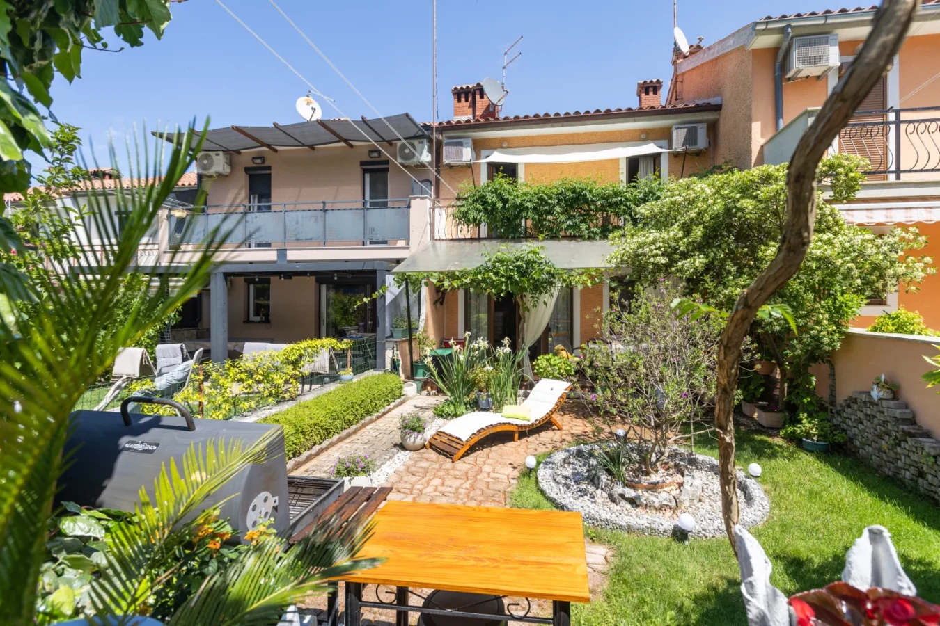 Landscaped backyard patio with lounge chairs and garden