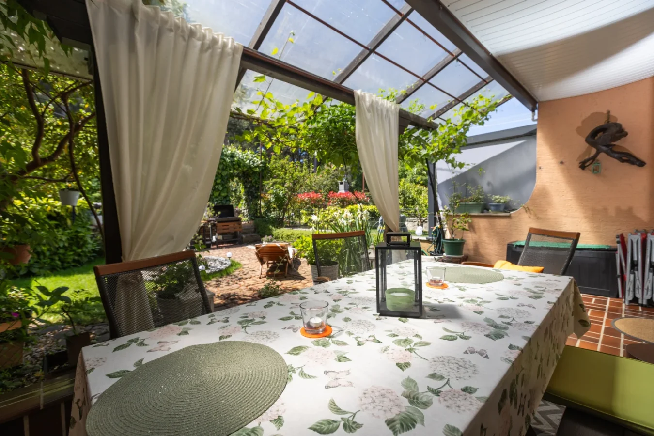 Covered patio dining area overlooking lush garden