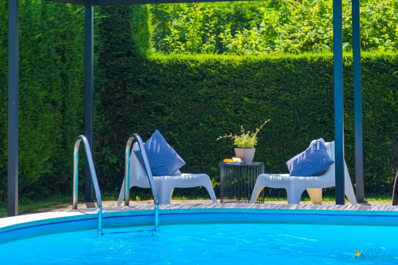 Cozy poolside chairs and table in garden